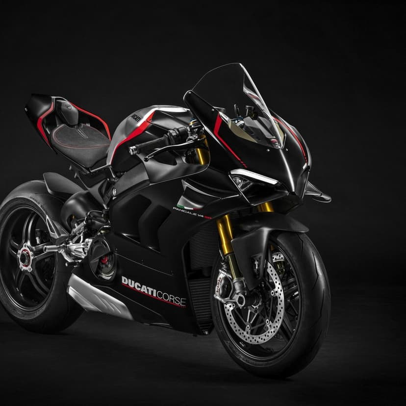 Matte black Ducati Panigale V4 SP motorcycle with red accents and gold forks against a dark studio background.