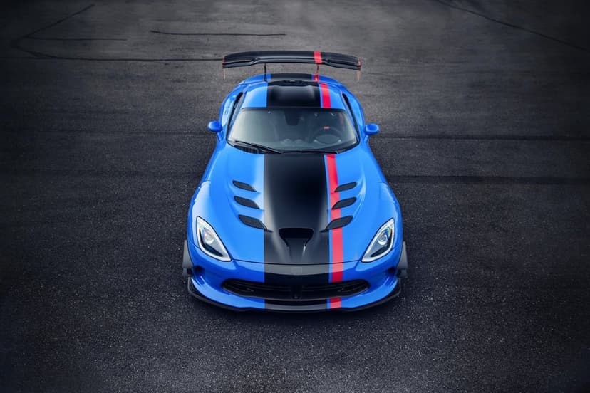 Blue Dodge Viper ACR with black and red racing stripes on a dark asphalt road with a large rear wing.
