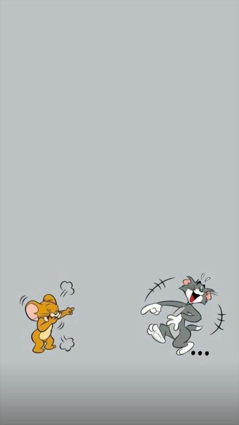 Jerry the mouse points and laughs at a shocked Tom the cat against a solid neutral gray background.