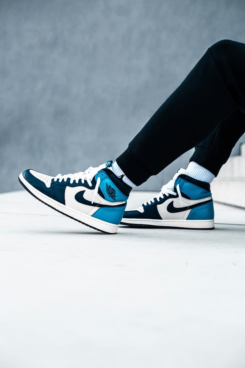 Dark Marina Blue Air Jordan 1 high-top sneakers with white leather accents and blue laces shown in a close-up.