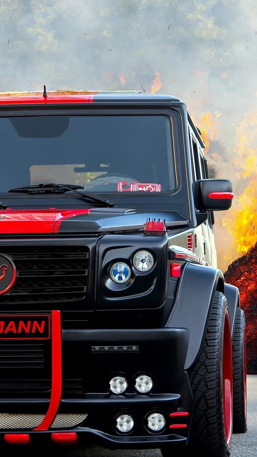 Black Mercedes-Benz G-Wagon with red highlights parked against a backdrop of orange flames and dark smoke clouds.