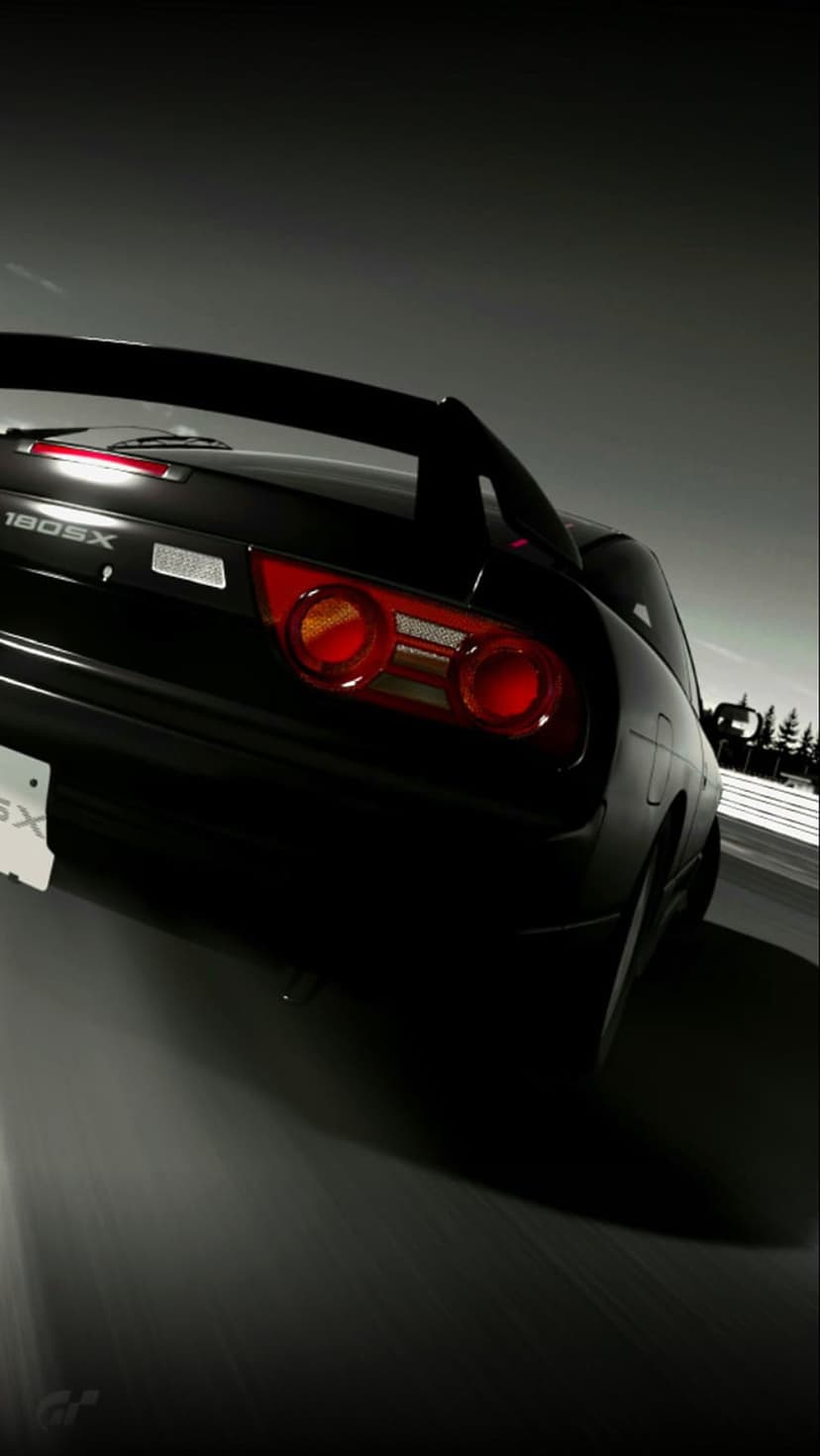 Nissan 180SX rear taillights and bumper visible on a dark road with motion blur in a black and white photograph.