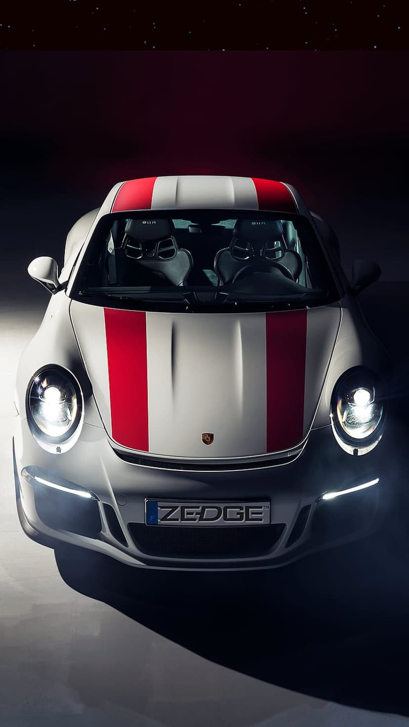 White Porsche 911 GT3 with red racing stripes parked in a dark studio with starry highlights and round headlights.