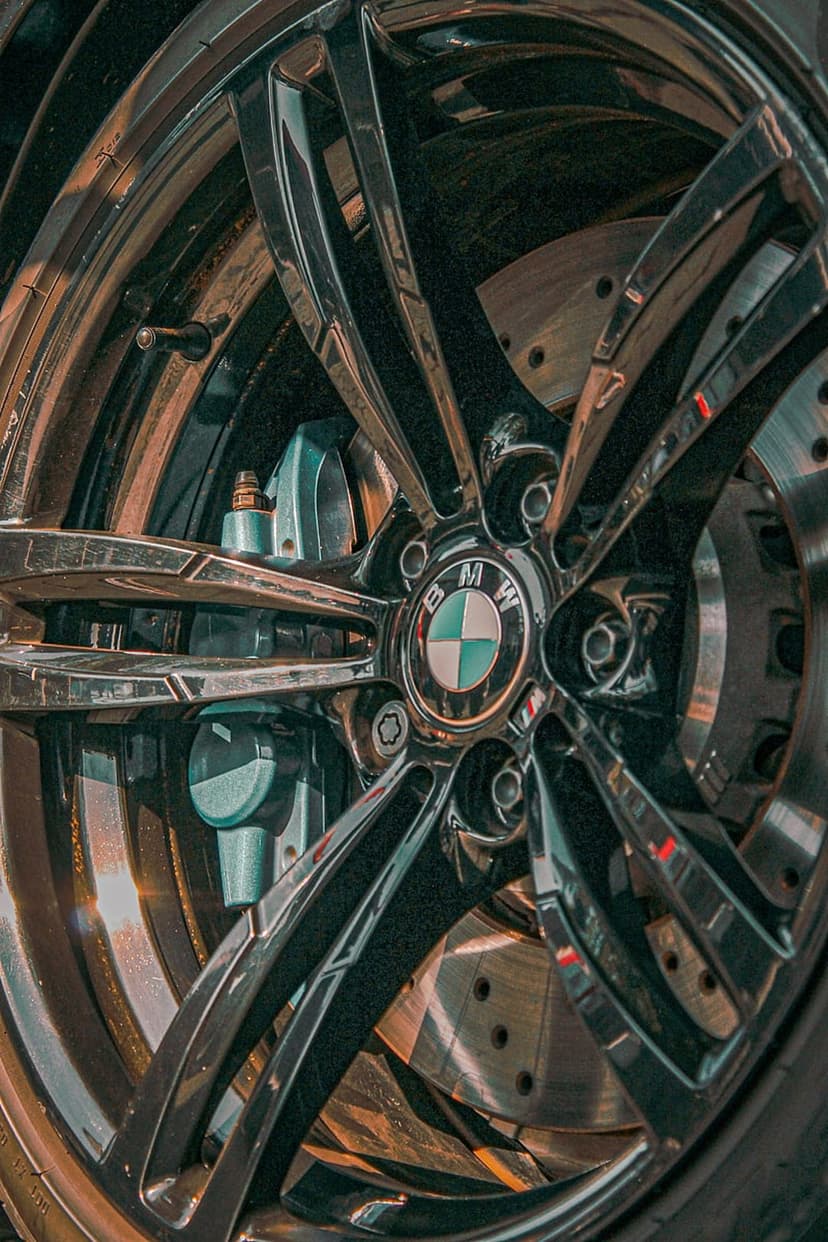 Blue BMW M-sport brake caliper and polished alloy rim with the iconic logo emblem shown in a detailed close-up.