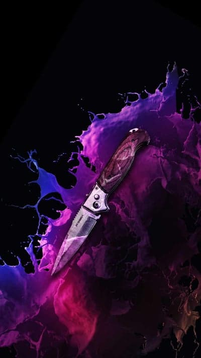 Knife With Purple and Blue Splashes Against Black