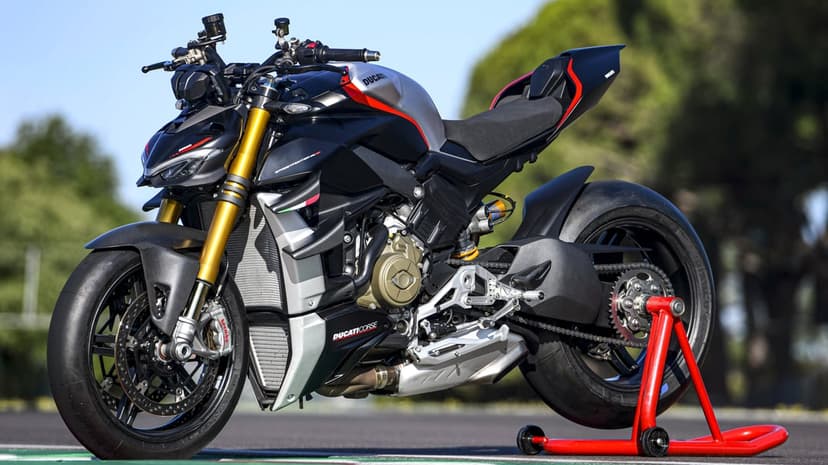 Ducati Streetfighter V4 SP motorcycle with gold forks on a red paddock stand against a blurred outdoor background.