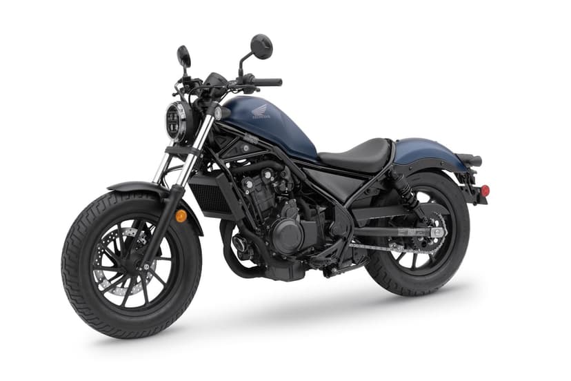 Matte blue Honda Rebel cruiser motorcycle with blacked-out engine and frame on a white studio background.