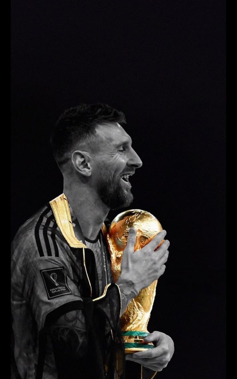 Lionel Messi closes his eyes while holding the World Cup trophy against a dark, high-contrast background.