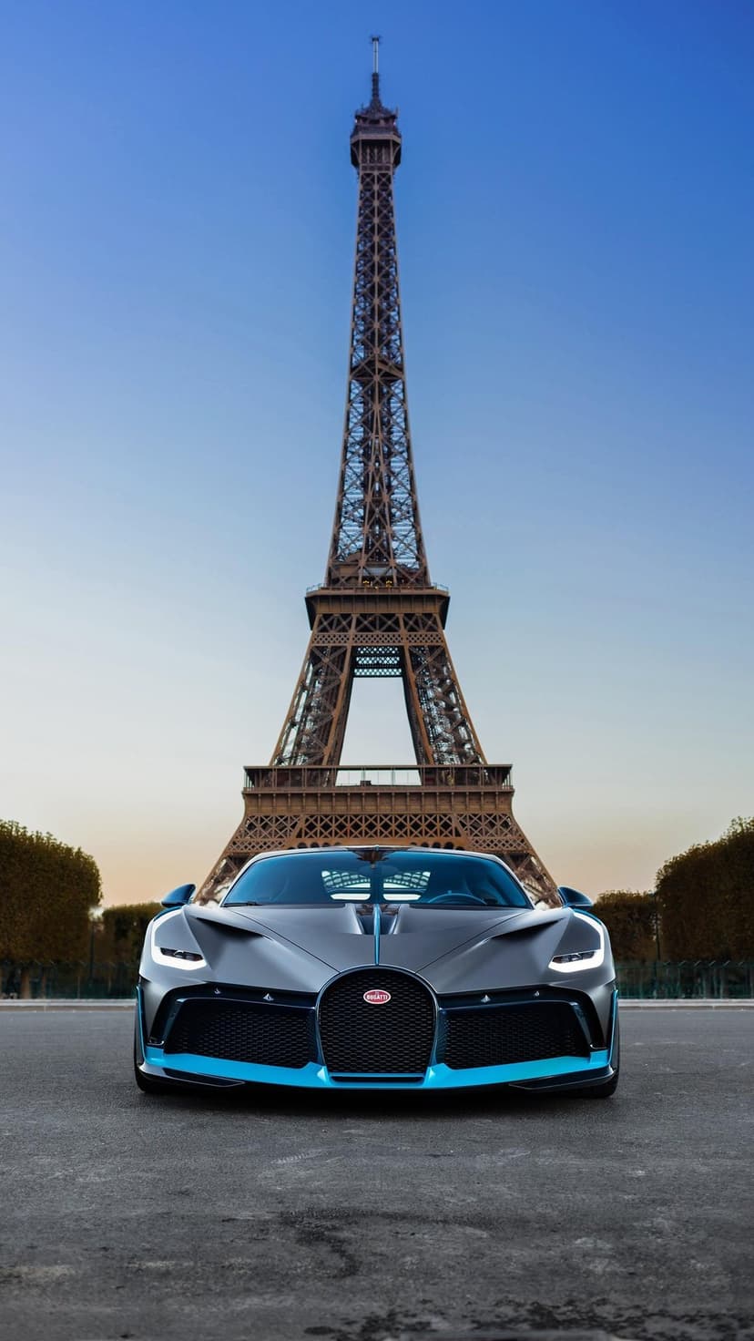 Bugatti Divo hypercar with blue trim centered in front of the Eiffel Tower under a clear twilight sky in Paris.