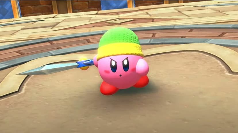 Determined pink Kirby character lunging with a sword while wearing a green beanie in a stone fighting arena.