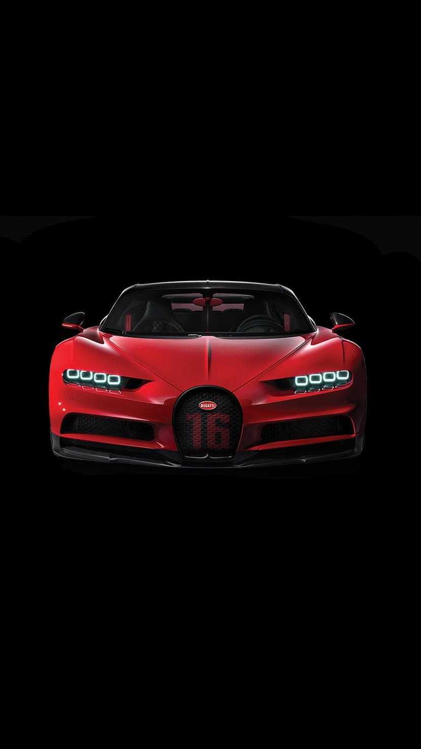 Red Bugatti Chiron hypercar with glowing LED headlights and a black horseshoe grille against a dark background.