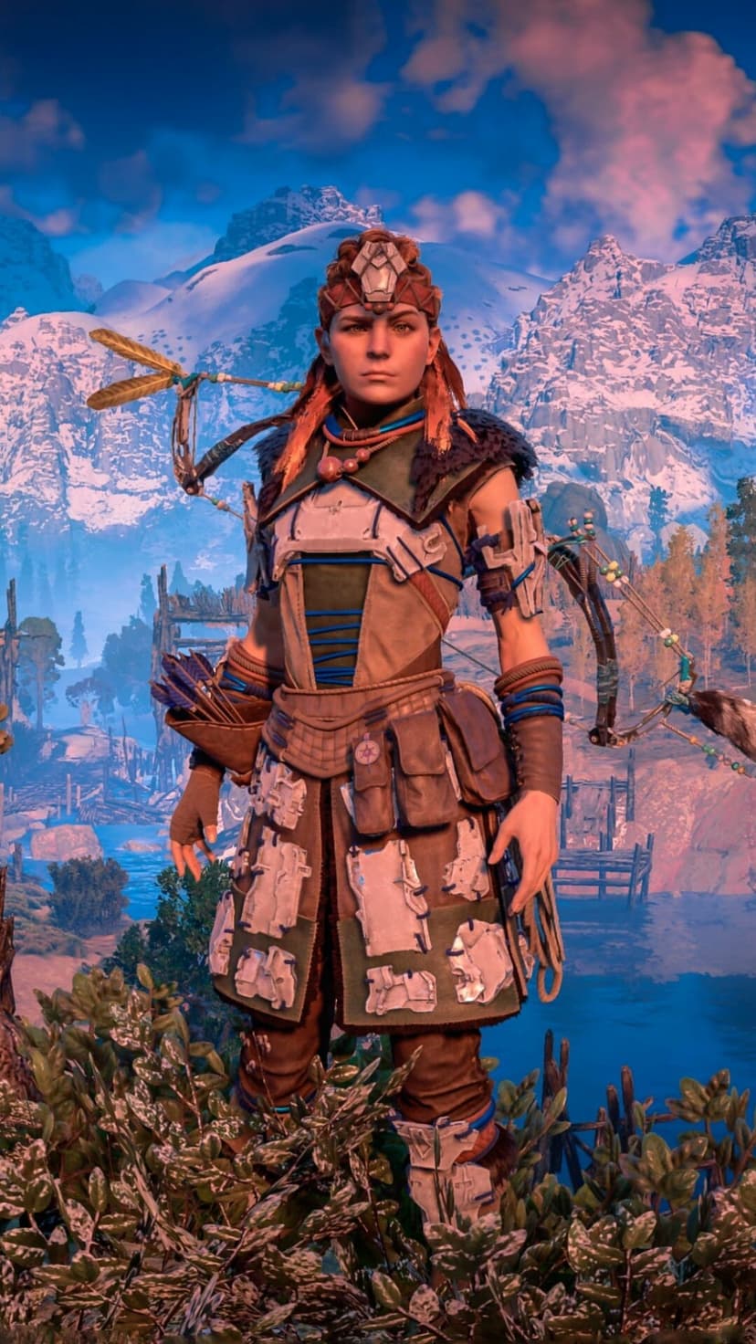 Aloy in detailed Nora armor holding a bow, set against snowy mountains and a vibrant pink sunset sky background.