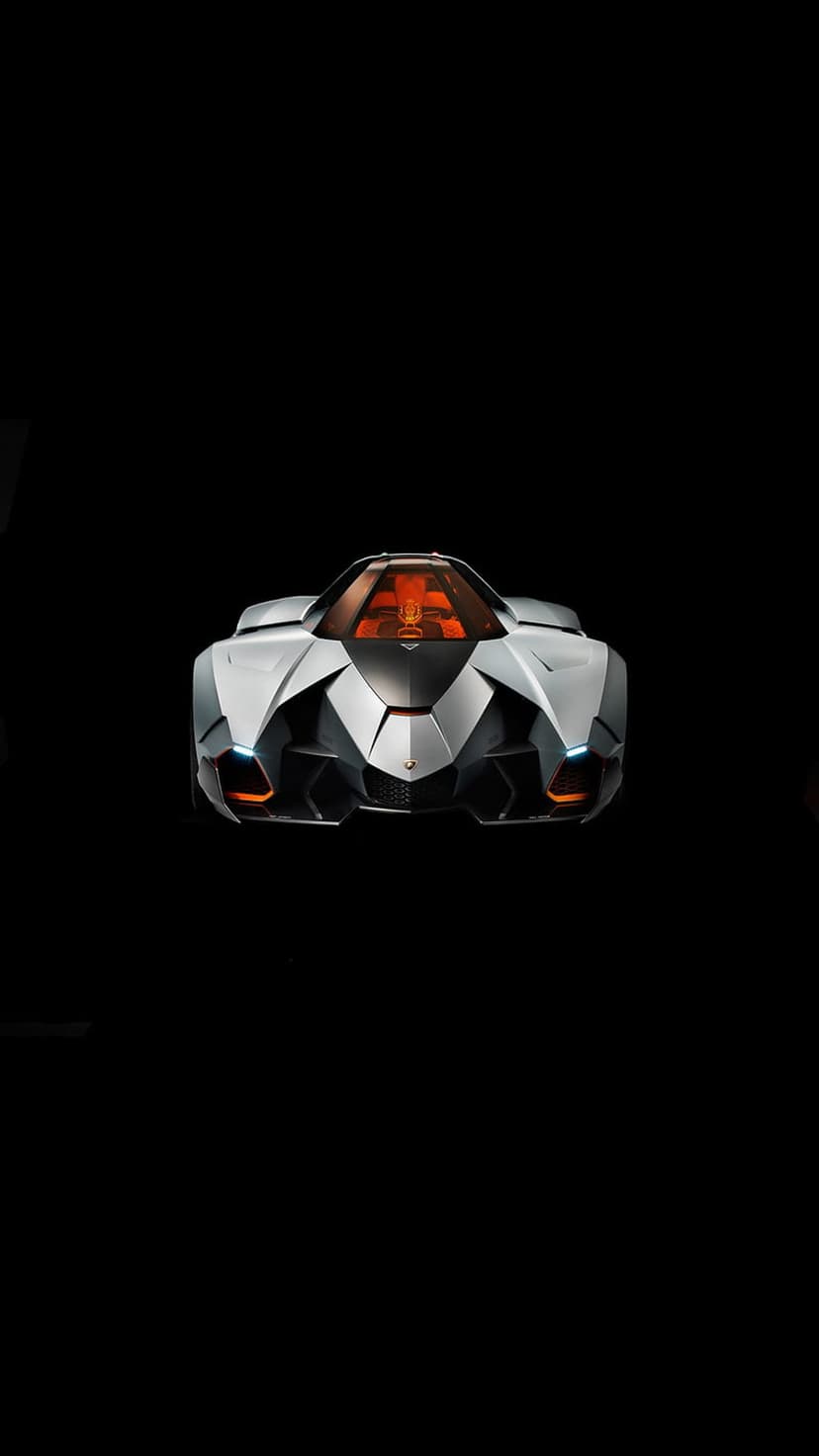 Silver concept car with orange seats and glowing LED headlights angled forward against a black backdrop.