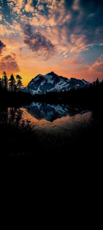 Sunset Over Snowy Mountains Reflected in a Calm Lake
