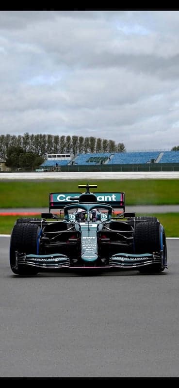 Aston Martin F1 car on track under cloudy skies