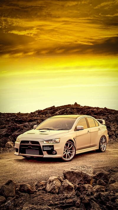 White Mitsubishi Lancer Evolution X on Rocky Terrain