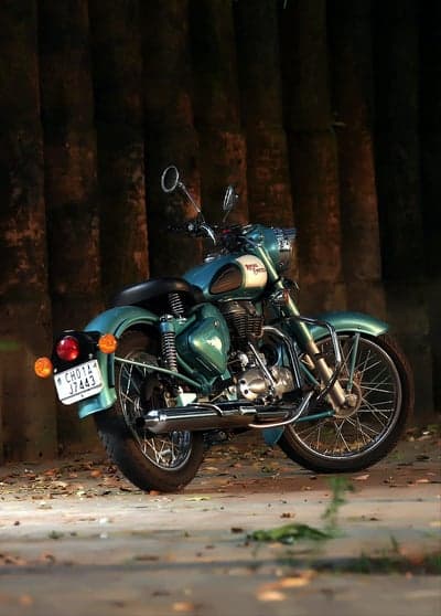 Vintage Teal Royal Enfield Motorcycle on Forest Floor