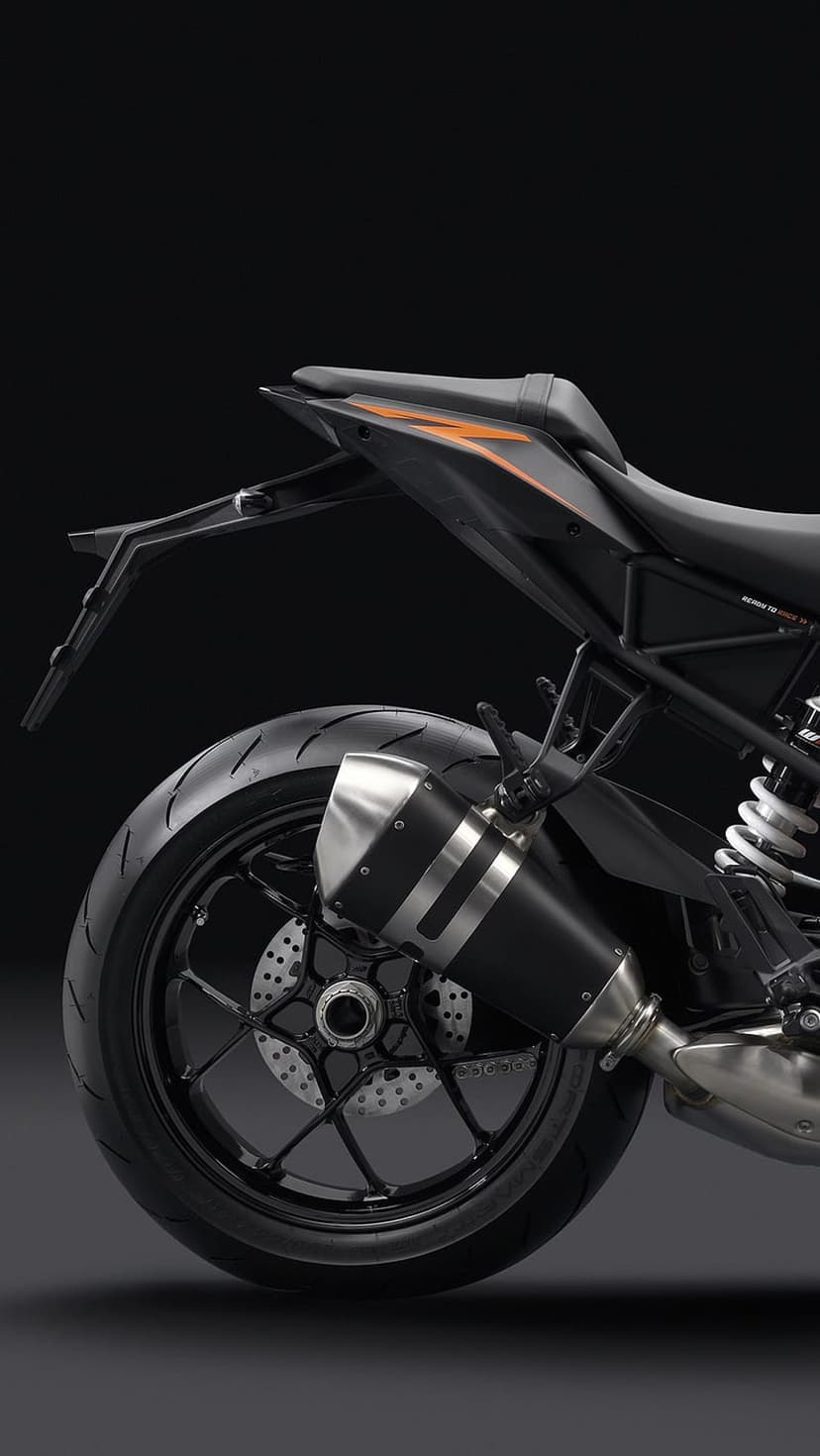 KTM motorcycle rear wheel featuring a perforated brake disc and a sleek black exhaust with orange tail accents.