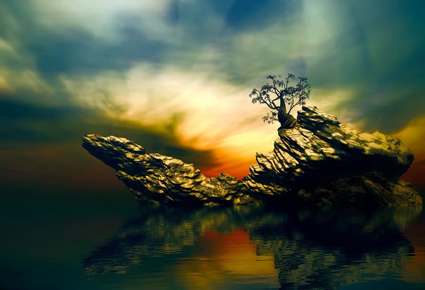 Lone leafless tree on a craggy stone island silhouetted against an orange and blue sunset sky over calm water.