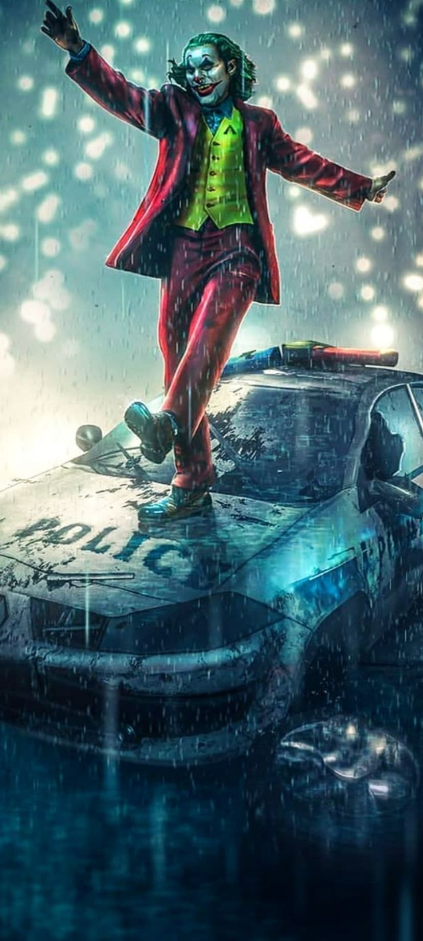Joker in purple suit stands on a damaged police car during heavy rain with blurred neon city lights behind him.
