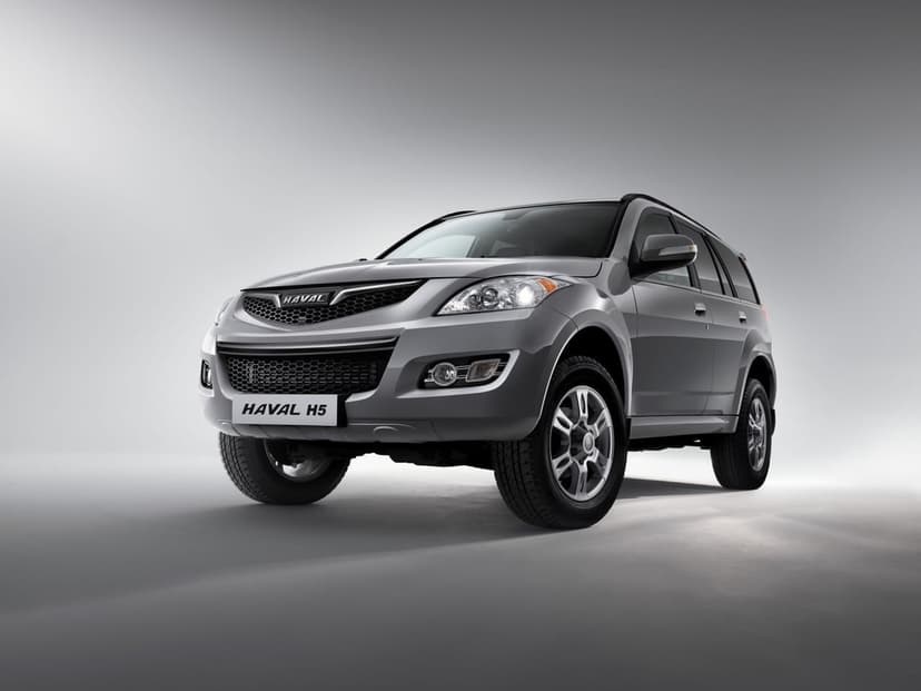Silver Haval H5 SUV in a studio with soft lighting, reflecting on a clean grey floor in landscape orientation.