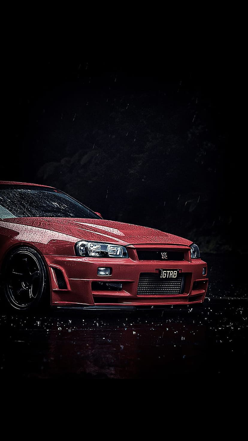 Red Nissan GT-R R34 parked on wet asphalt at night with raindrops glistening on the hood and front bumper.