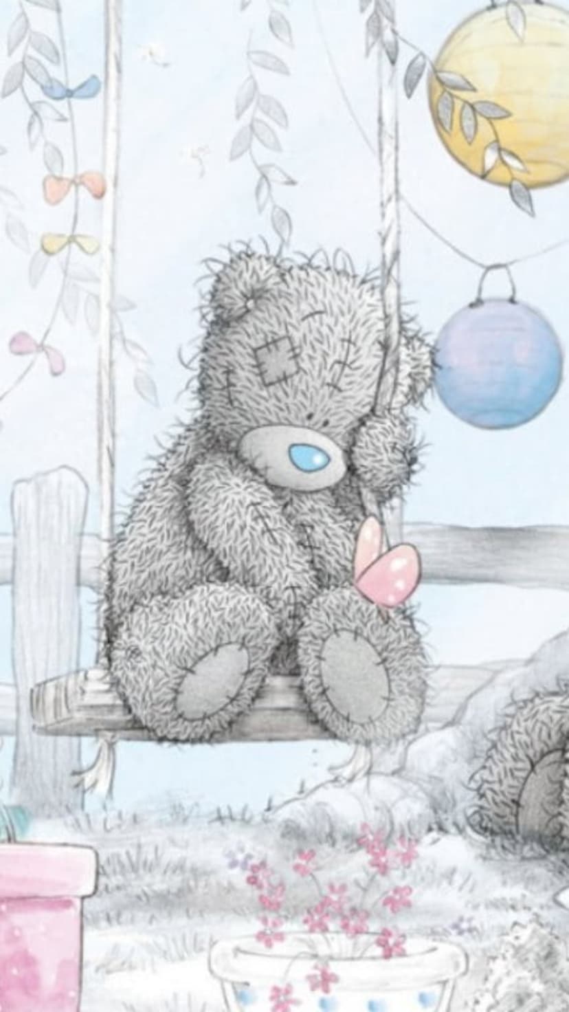 Tatty Teddy bear with a blue nose sits on a wooden swing while holding a small pink butterfly near lanterns.