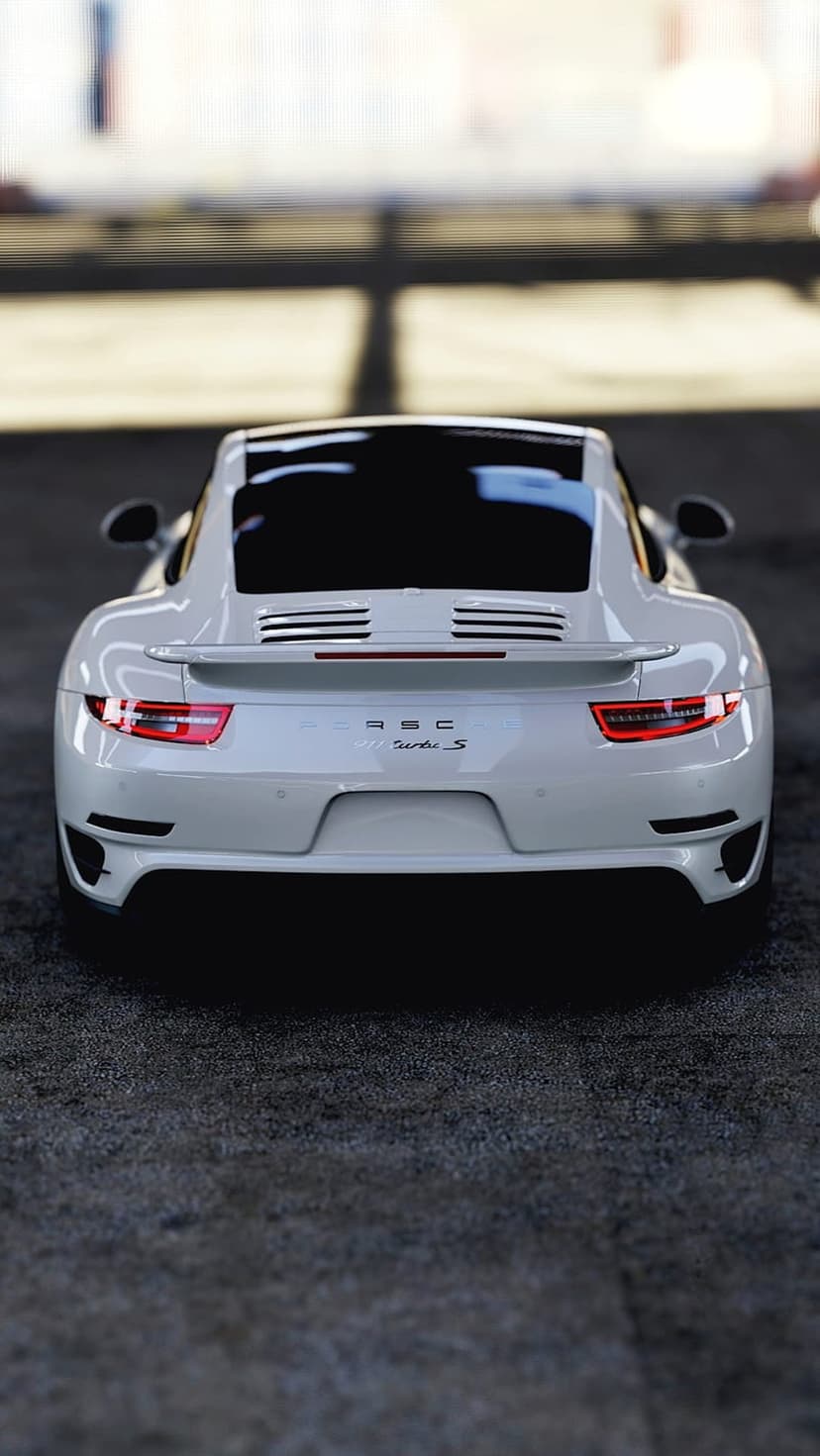 Porsche 911 Turbo S rear view featuring white paint, a large spoiler, and a glowing red LED taillight strip.