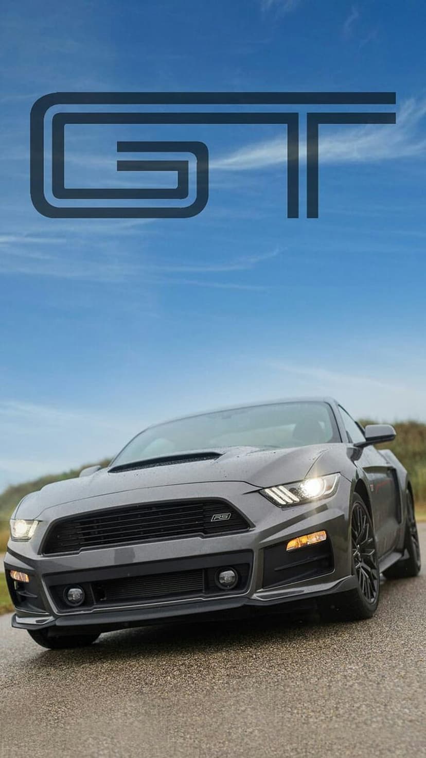 Gray Ford Mustang GT on a wet road with glowing headlights under a blue sky with a GT logo at the top.