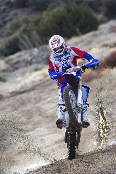 Motocross Rider Jumps Dirt Hill on Yamaha Motorcycle