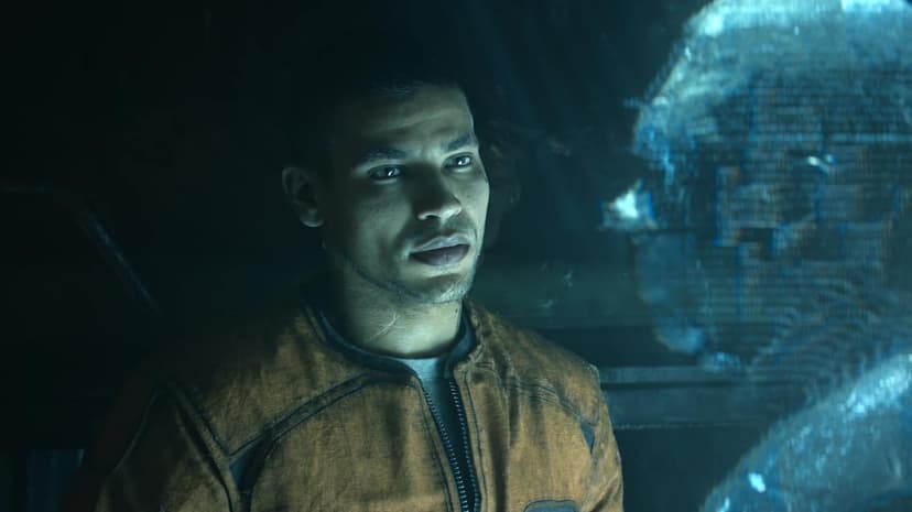 Elias in an orange jacket gazes at a blue holographic display in a dark, atmospheric sci-fi environment.