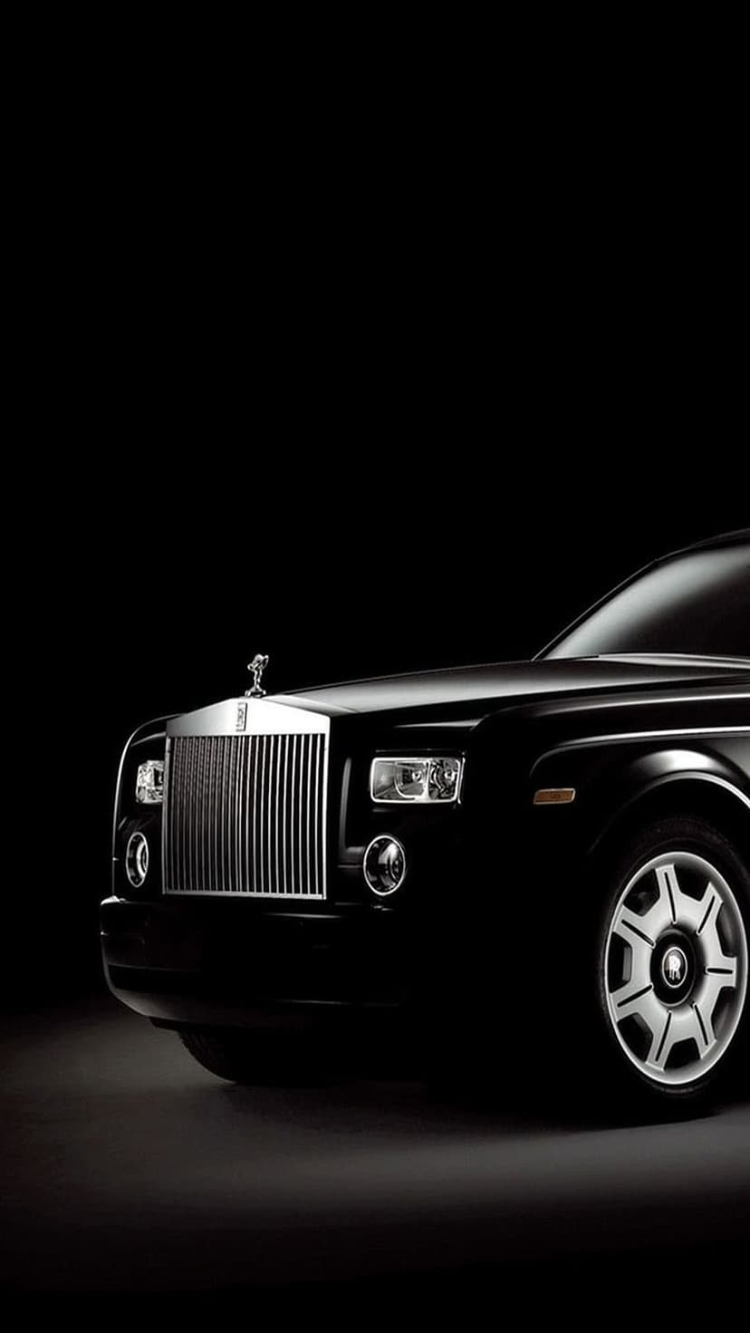 Rolls-Royce Phantom front grille and Spirit of Ecstasy ornament centered against a dark, shadowy background.
