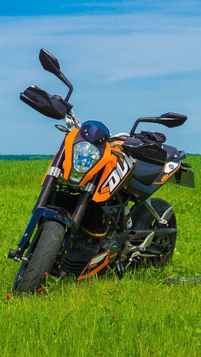 Orange KTM Duke Motorcycle Parked in Green Field
