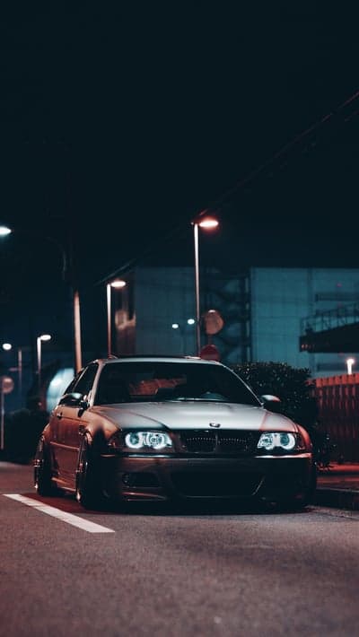 Modified BMW E46 coupe at night, street racing aesthetic