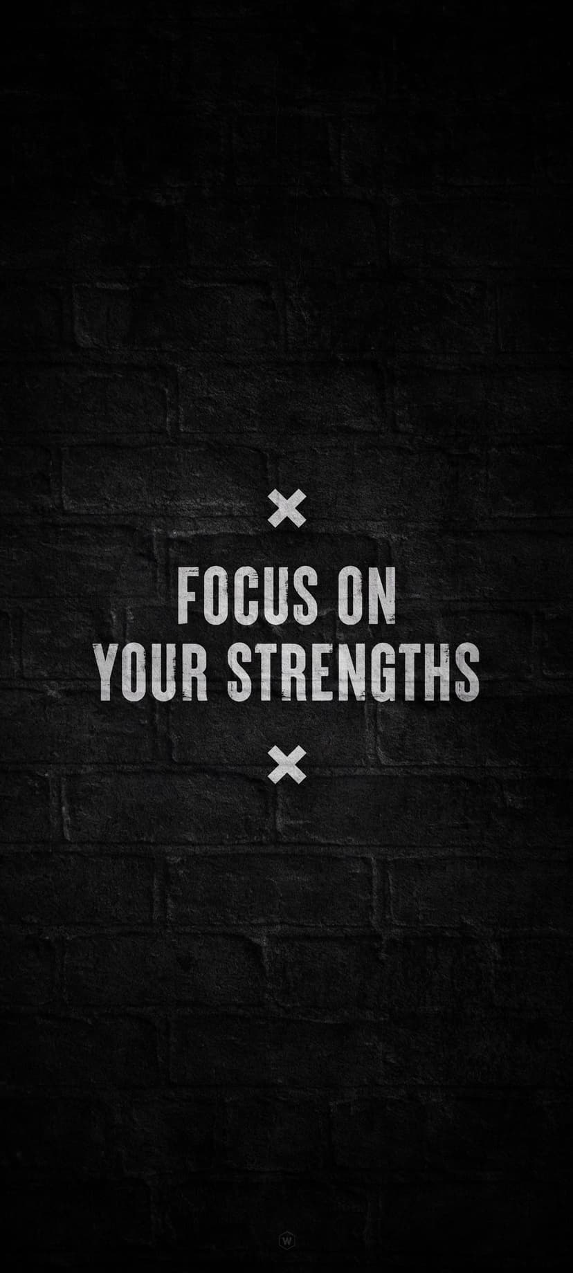 FOCUS ON YOUR STRENGTHS text in white sans-serif font over a dark, textured brick wall with minimalist x marks.