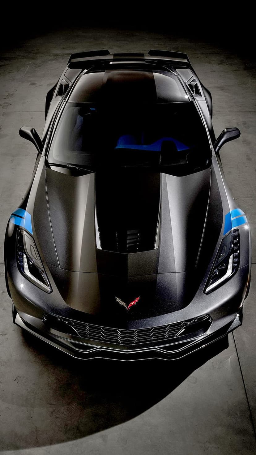 Matte black Corvette Z06 with blue stripes viewed from above, highlighting the front grille and hood emblem.