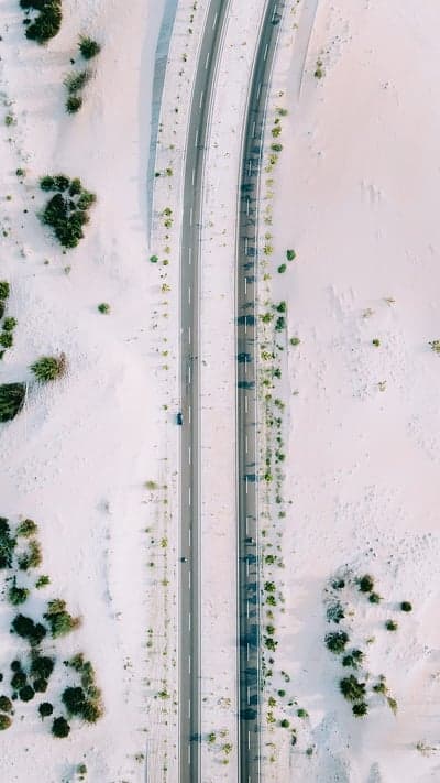 Minimalist Desert Highway Through Sand Dunes Background