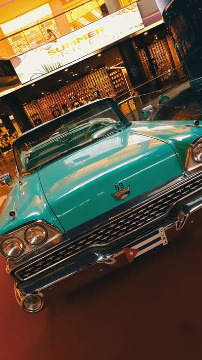 Vintage Teal Convertible Car with Cuba Flag
