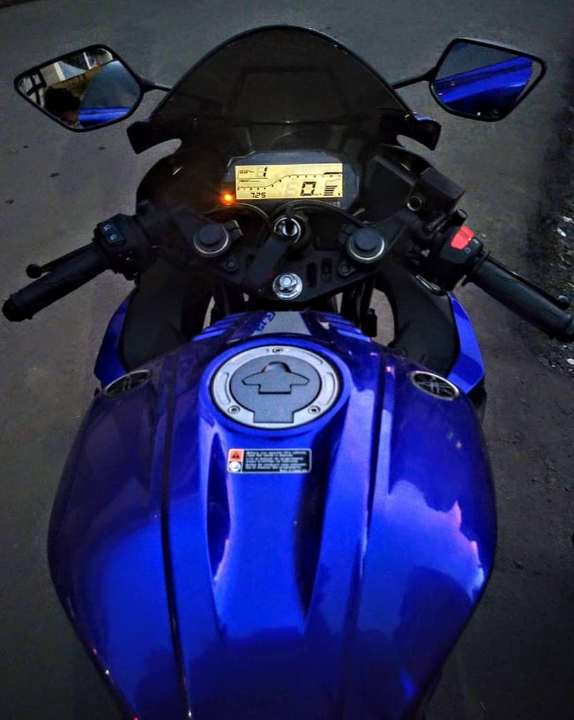 Yamaha R15 digital dashboard showing speed and gear indicators next to a polished blue metallic fuel tank.