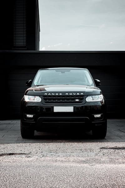 Black Range Rover parked in front of modern black building