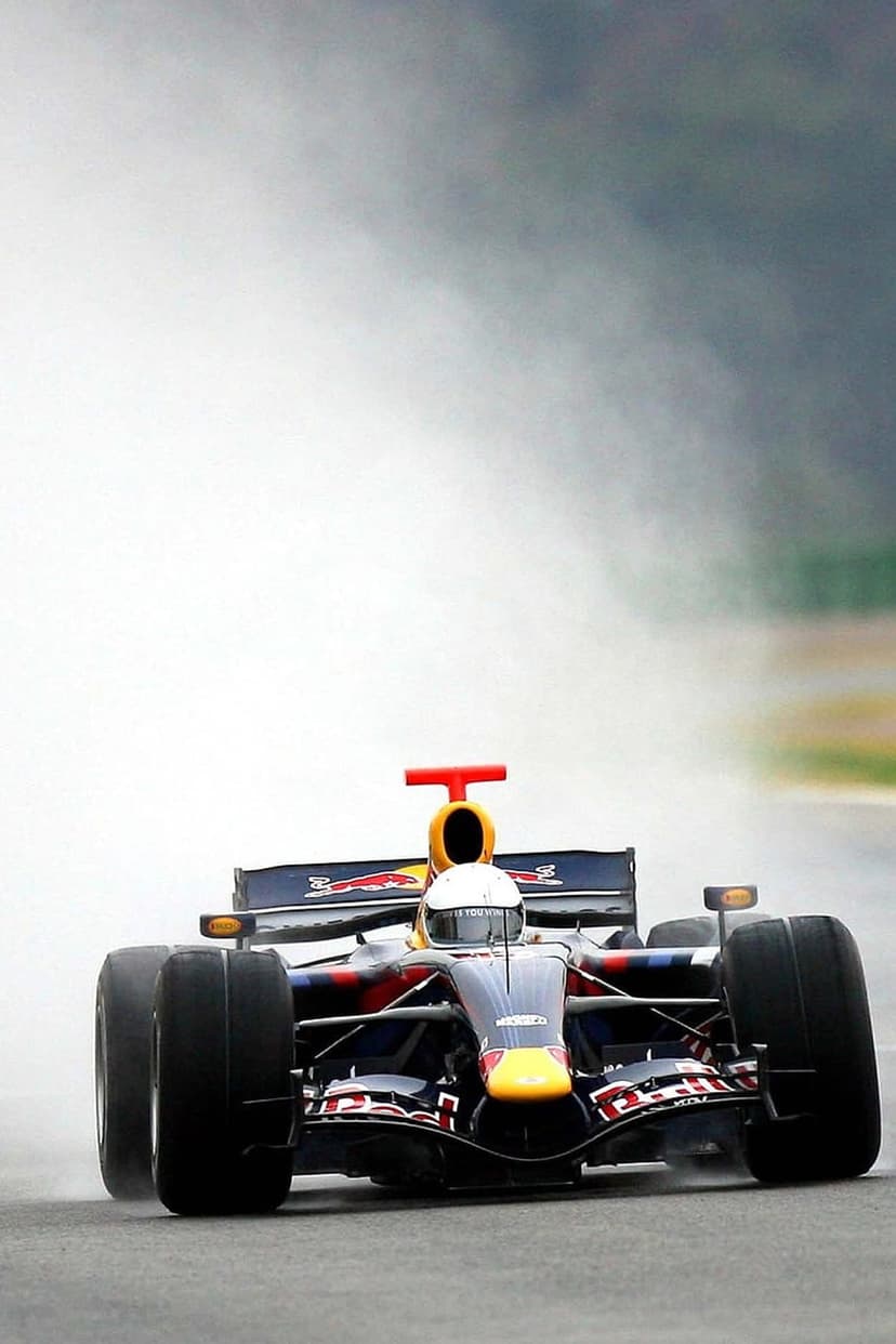 Red Bull Formula 1 car driving through heavy rain and spray on a wet track with visible aerodynamic details.