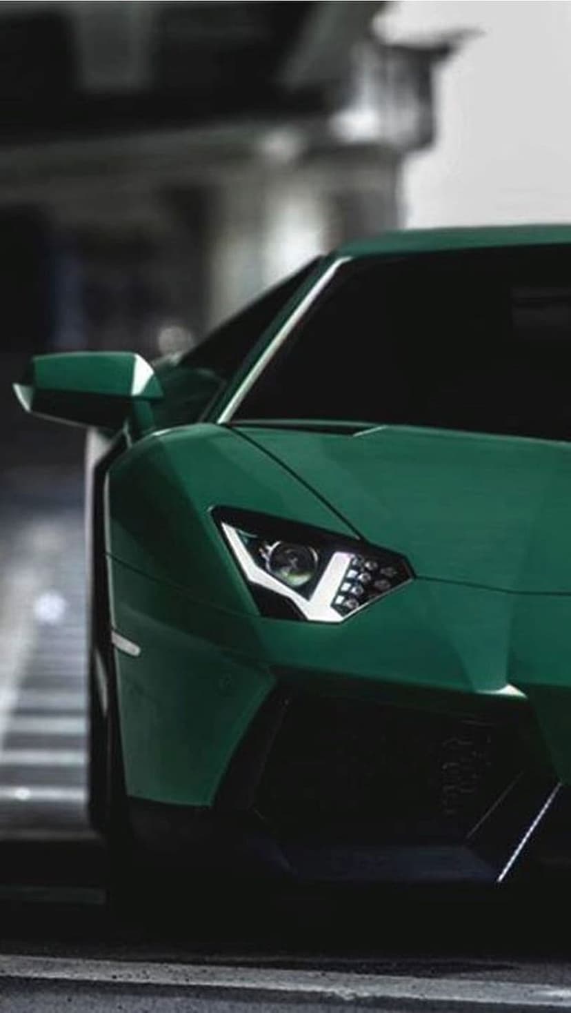 Lamborghini Aventador LED headlight and green fender captured in a low-angle close-up with a blurred background.