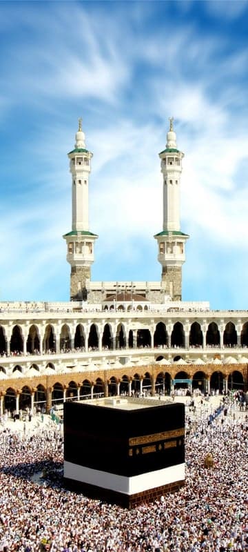 Pilgrims surrounding the Kaaba in Mecca under a cloudy sky