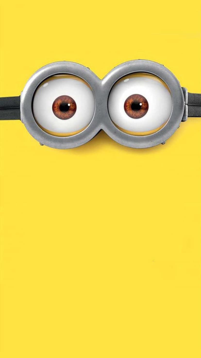 Minion goggles with silver metallic frames and brown eyes centered on a bright yellow vertical background.