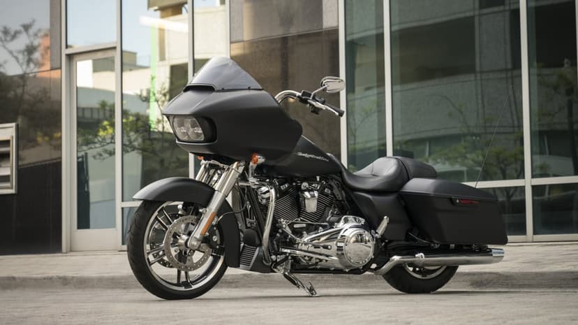 Matte black Harley-Davidson Road Glide with chrome details parked in front of a glass urban building.