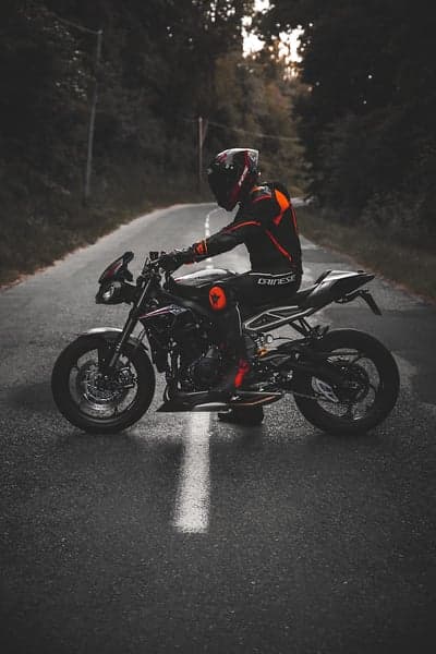 Black Sportbike Rider on Wet Forest Road Phone Wallpaper