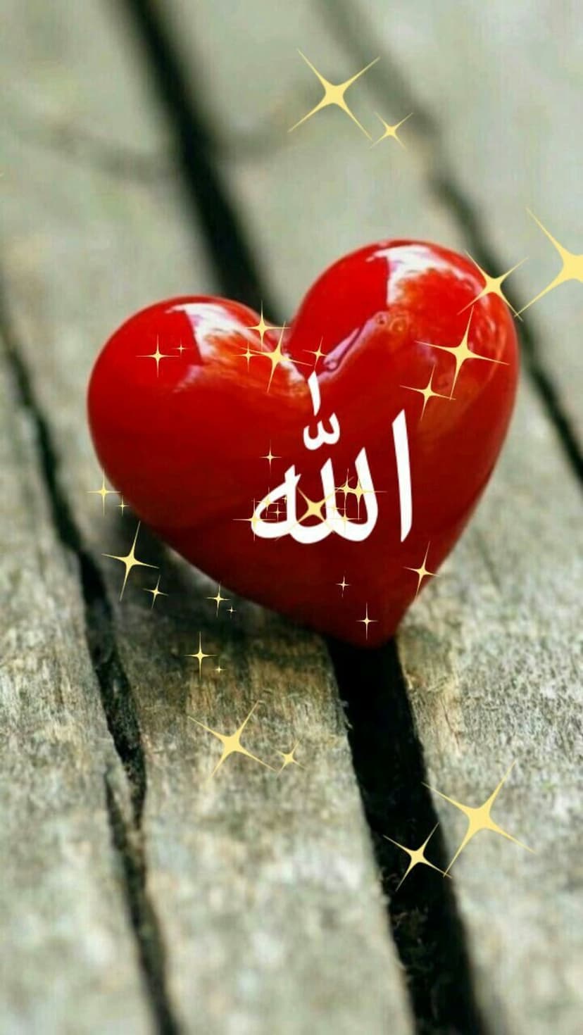 Red glossy heart with white Arabic Allah calligraphy rests on a rustic wood surface with gold sparkles.