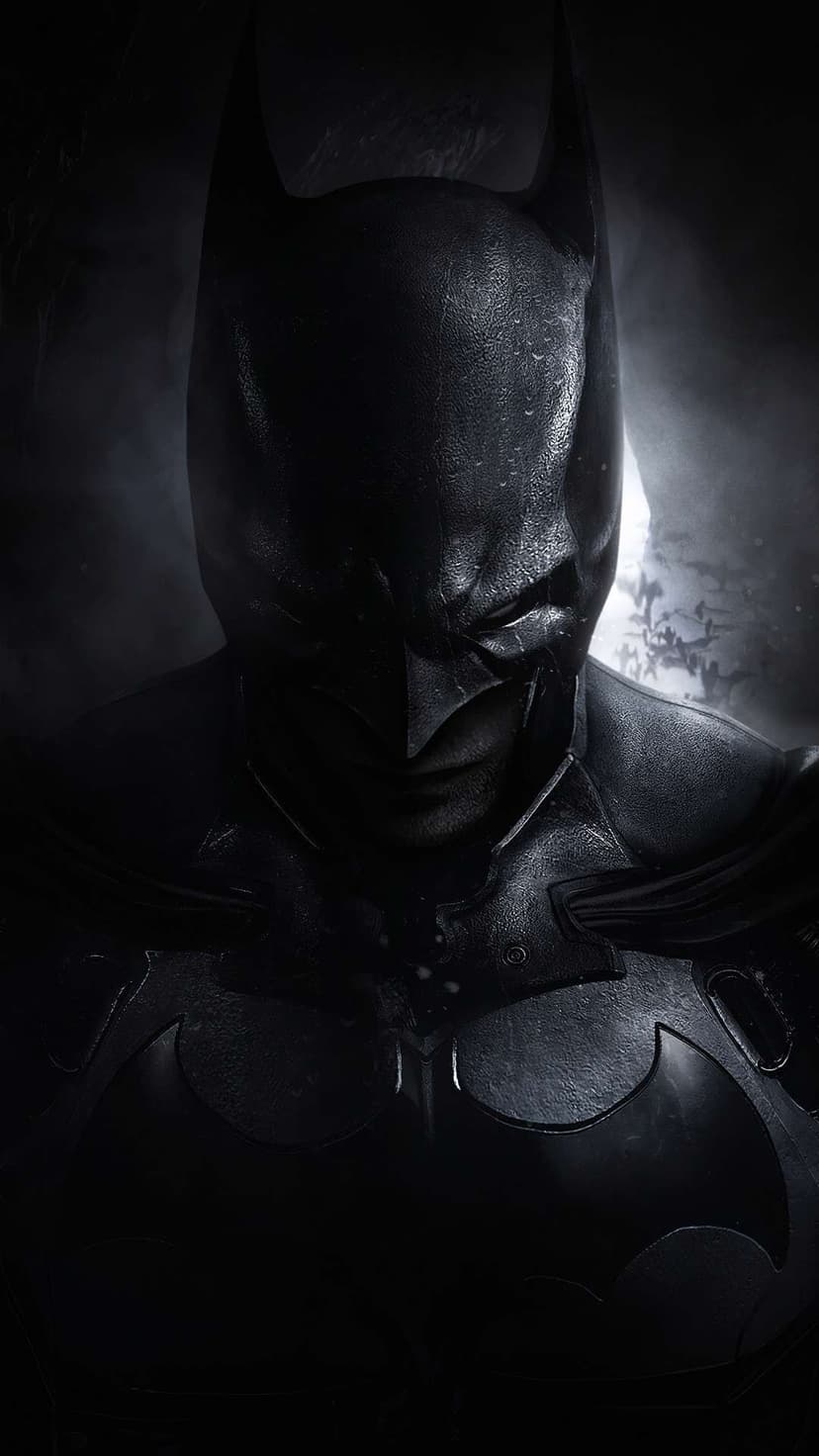 Batman's black cowl and bat-shaped chest emblem illuminated by a dim moon amidst swirling gray fog at night.