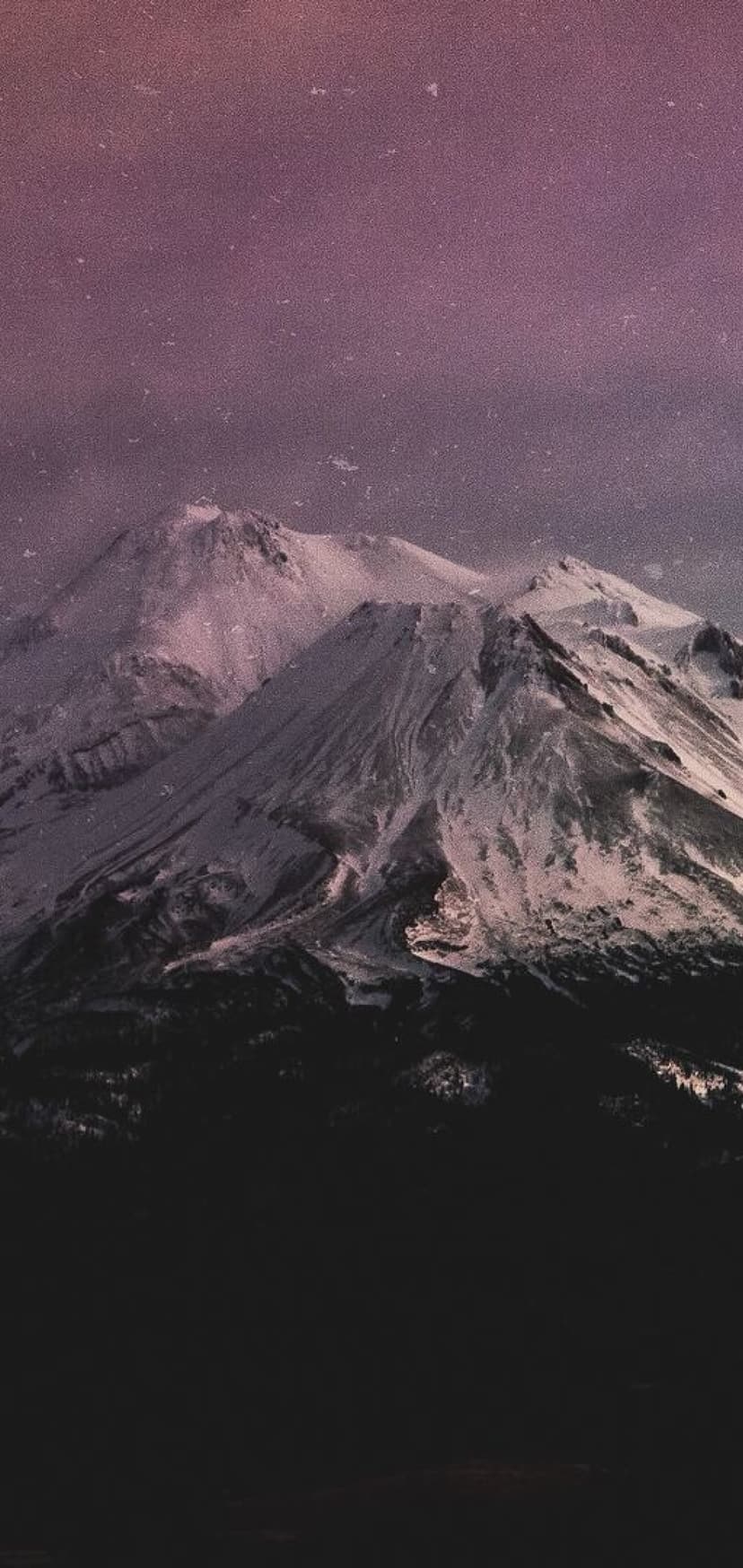 Snowy mountain peaks with jagged ridges glow under a violet night sky filled with faint stars and cosmic mist.