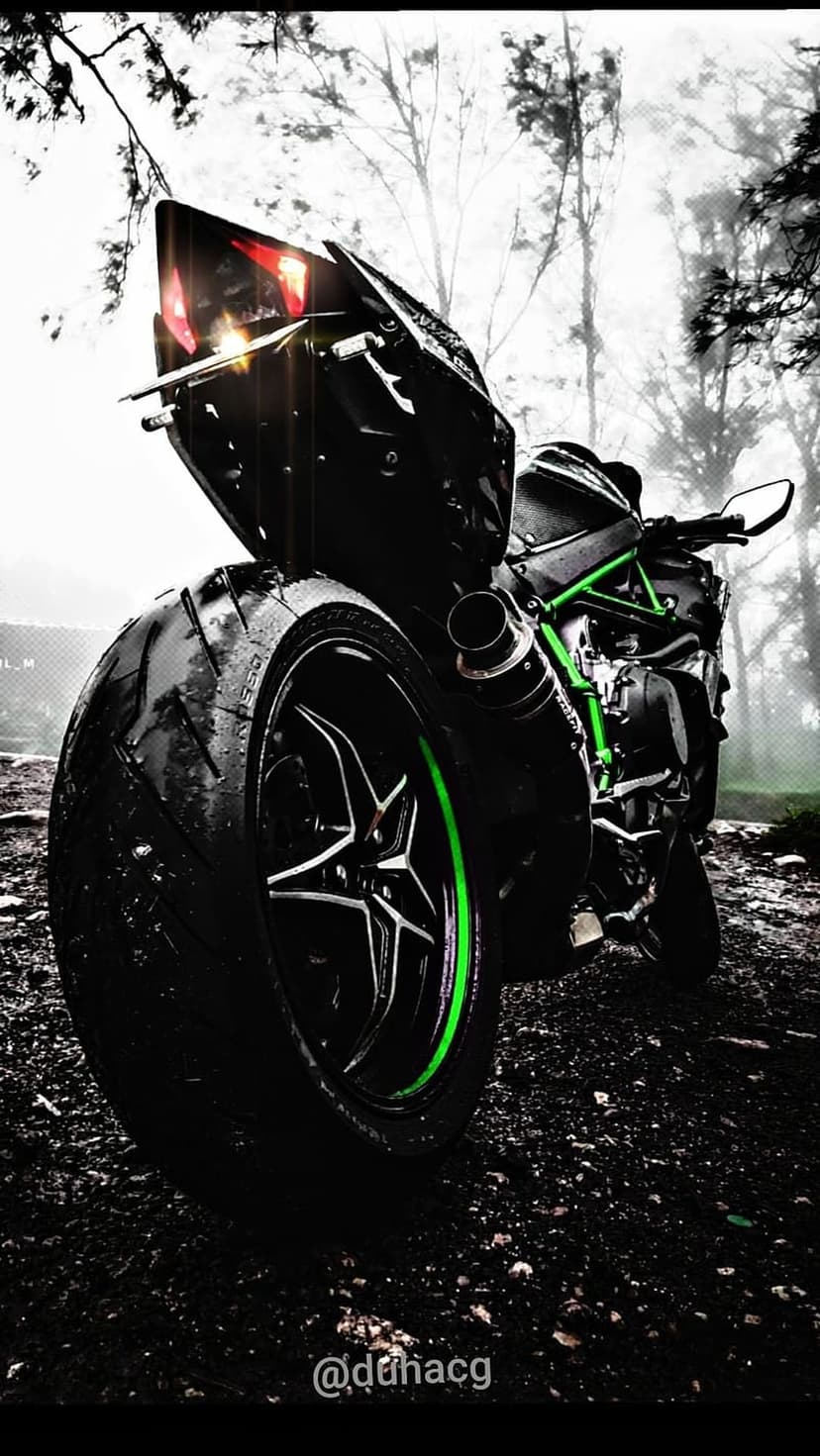 Kawasaki Ninja H2R motorcycle on wet pavement with lime green accents and a misty forest in the background.